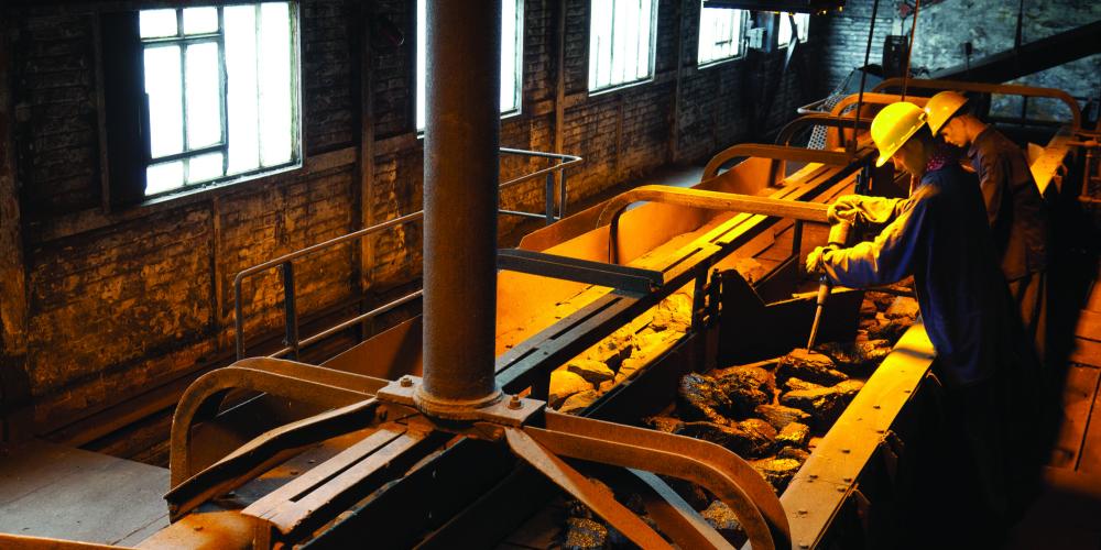 Workers use hammers to crush coal into smaller pieces in the sorting plant. – © FTPL