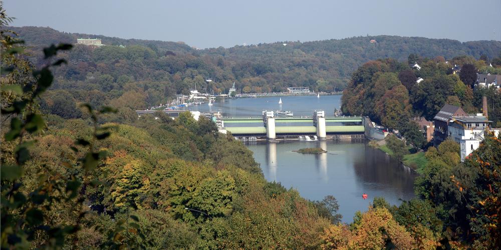 Le barrage bloque la Ruhr sur environ huit kilomètres pour former le lac de Baldeney. Une écluse relie les différents niveaux d'eau et une centrale hydroélectrique génère de l'électricité. Le barrage sert également de pont pour les piétons. – © Editing Department / City of Essen Le barrage bloque la Ruhr sur environ huit kilomètres pour former le lac de Baldeney. Une écluse relie les différents niveaux d'eau et une centrale hydroélectrique génère de l'électricité. Le barrage sert également de pont pour les piétons. – © Editing Department / City of Essen