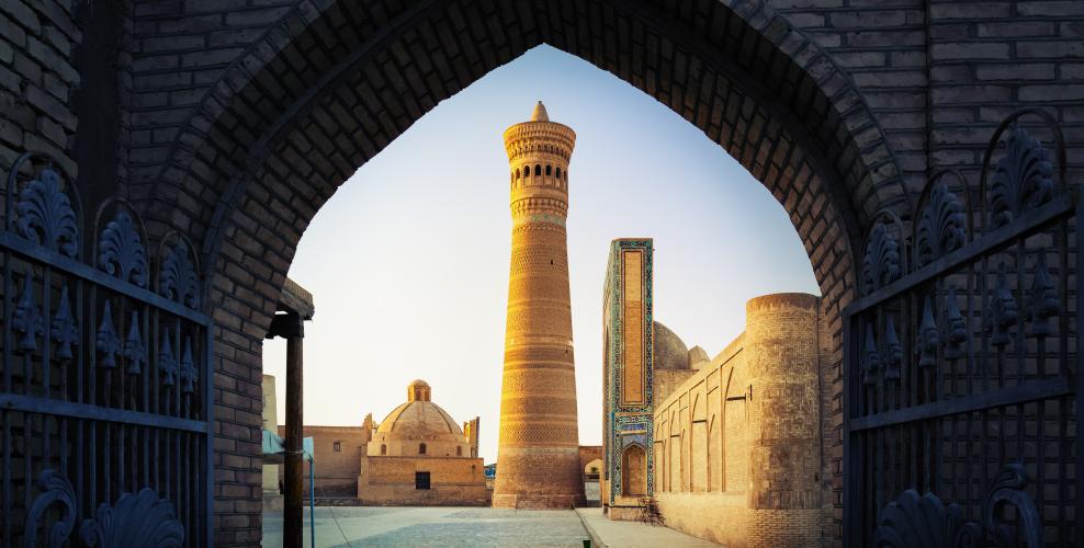 View into Poi-Kalyan islamic religious complex through gate in Bukhara, Uzbekistan – © Dudarev Mikhail / Shutterstock