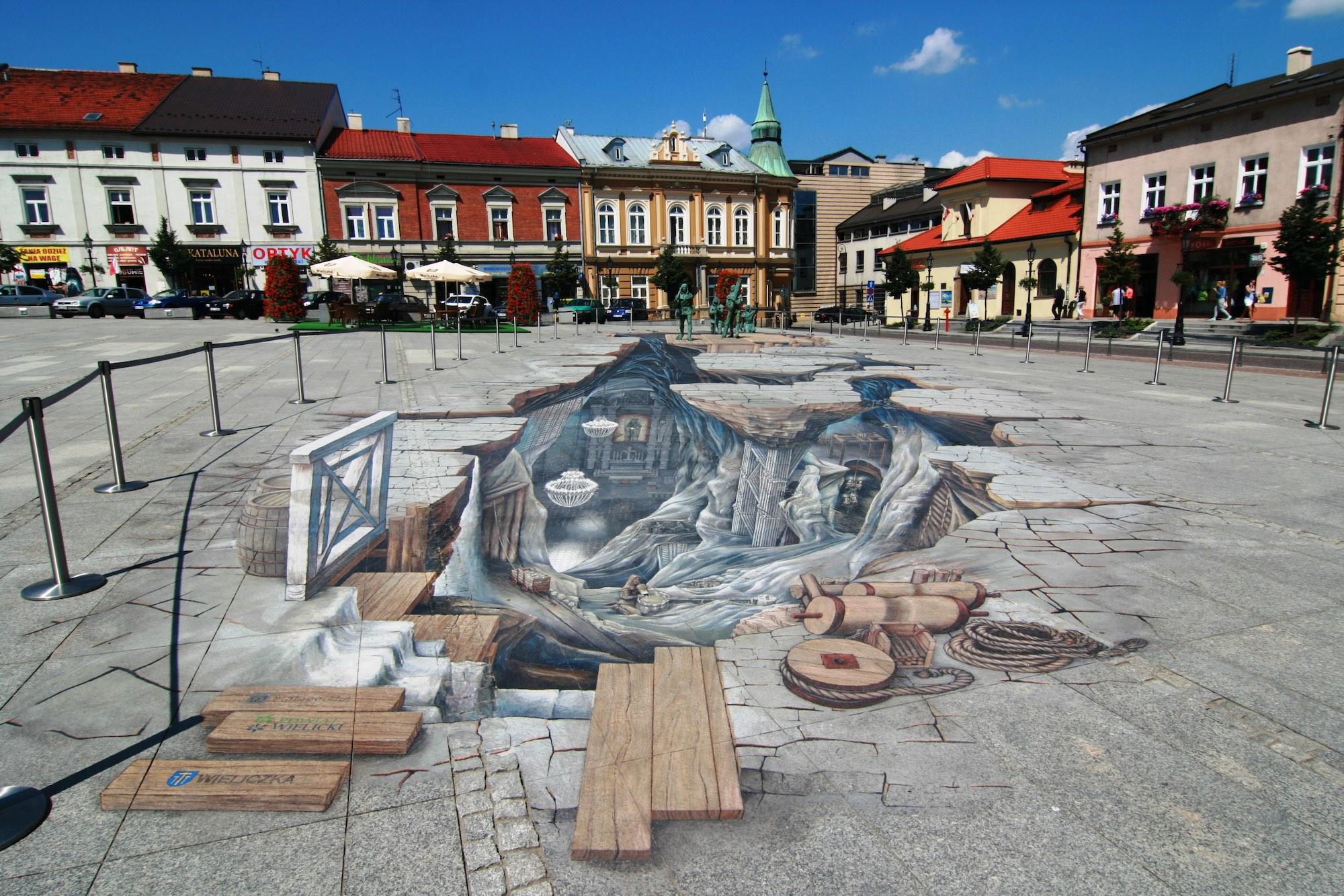 The trompe l'oeil painting in Wieliczka's Market Square gives the illusion of "peering" into the salt mine  below. – © Happa / Wikimedia Foundation