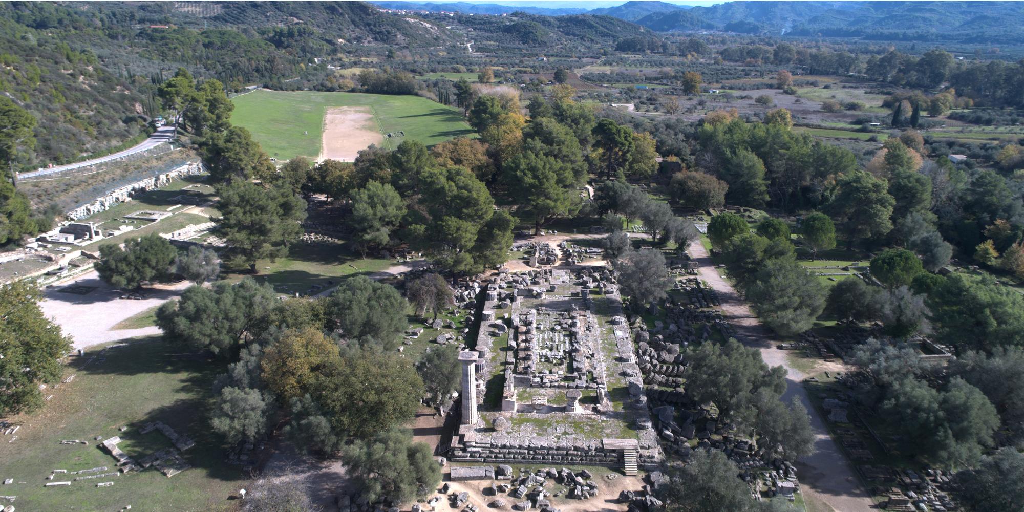 Vue du site d'Olympie avec le temple de Zeus au premier plan et le stade à l'arrière-plan. - © Ministère Hellénique de la Culture et des Sports / Ephorat des Antiquités d'Ilia