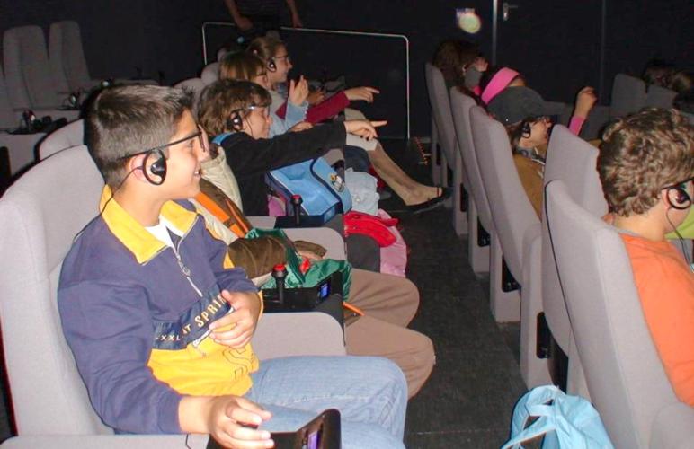 Kids enjoying a dramatised virtual tour in the Sanctuary of Zeus at the 3D Interactive Theatre – © Hellenic Ministry of Culture and Sports / Ephorate of Antiquities of Ilia