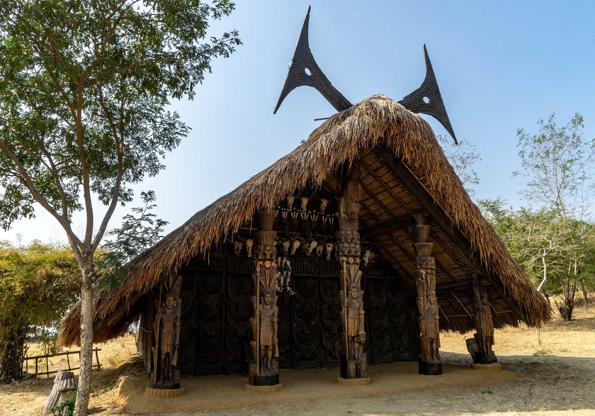 The Kunemechi ‘Rich Man House’ from the Chakhesang Naga tribe is embellished with a house horn, animal skulls, and carved wooden pillars. – © Michael Turtle