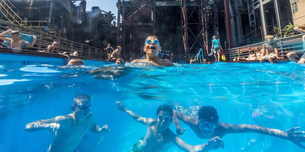 Pendant les vacances d'été en Rhénanie du Nord-Westphalie, cette piscine est un lieu de rencontre populaire pour les enfants et les adolescents des quartiers voisins et un symbole du changement structurel dans la région de la Ruhr. – © Jochen Tack / Zollverein Foundation