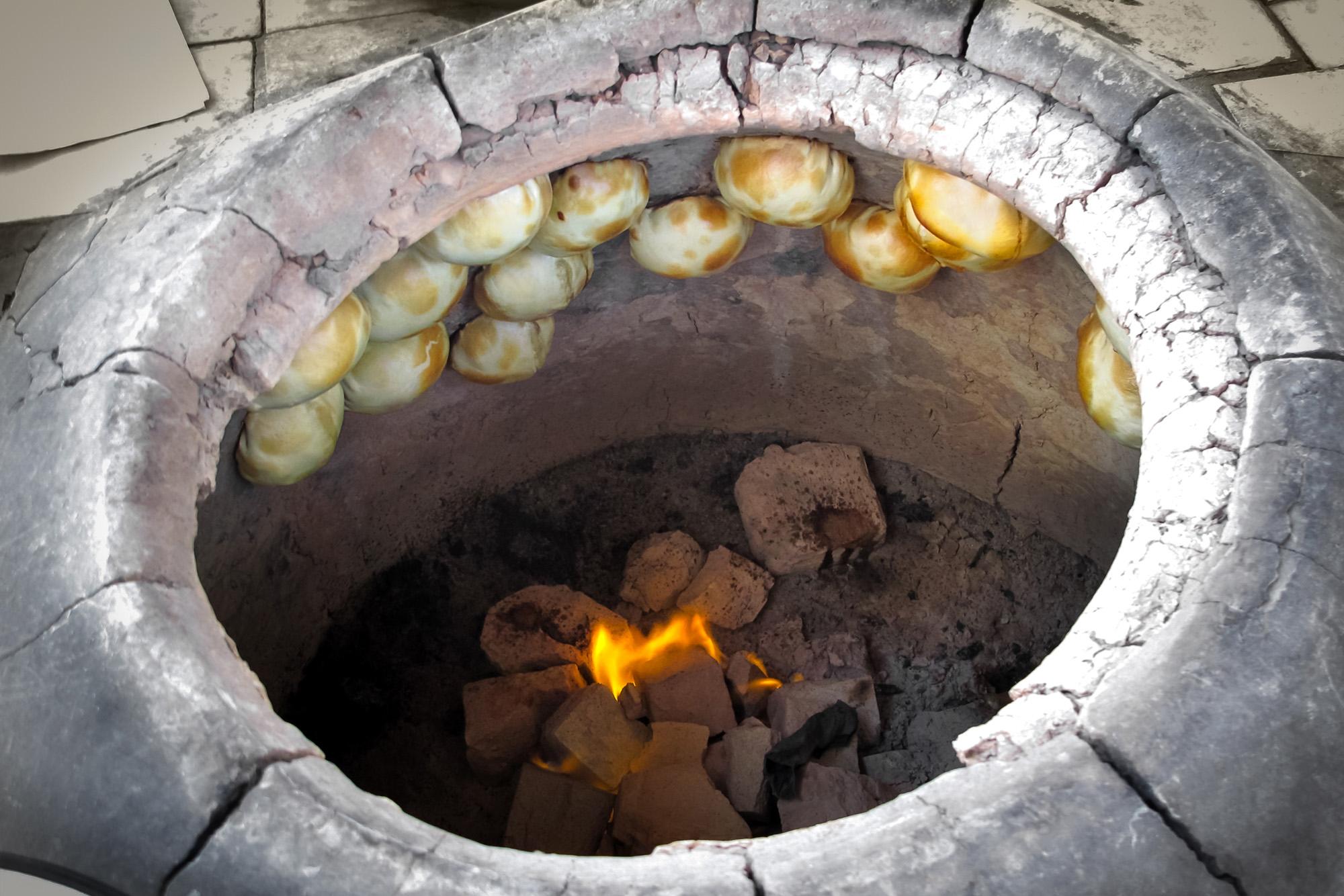 Baking bread the traditional way in a tandoor – © Ron Ramtang / Shutterstock