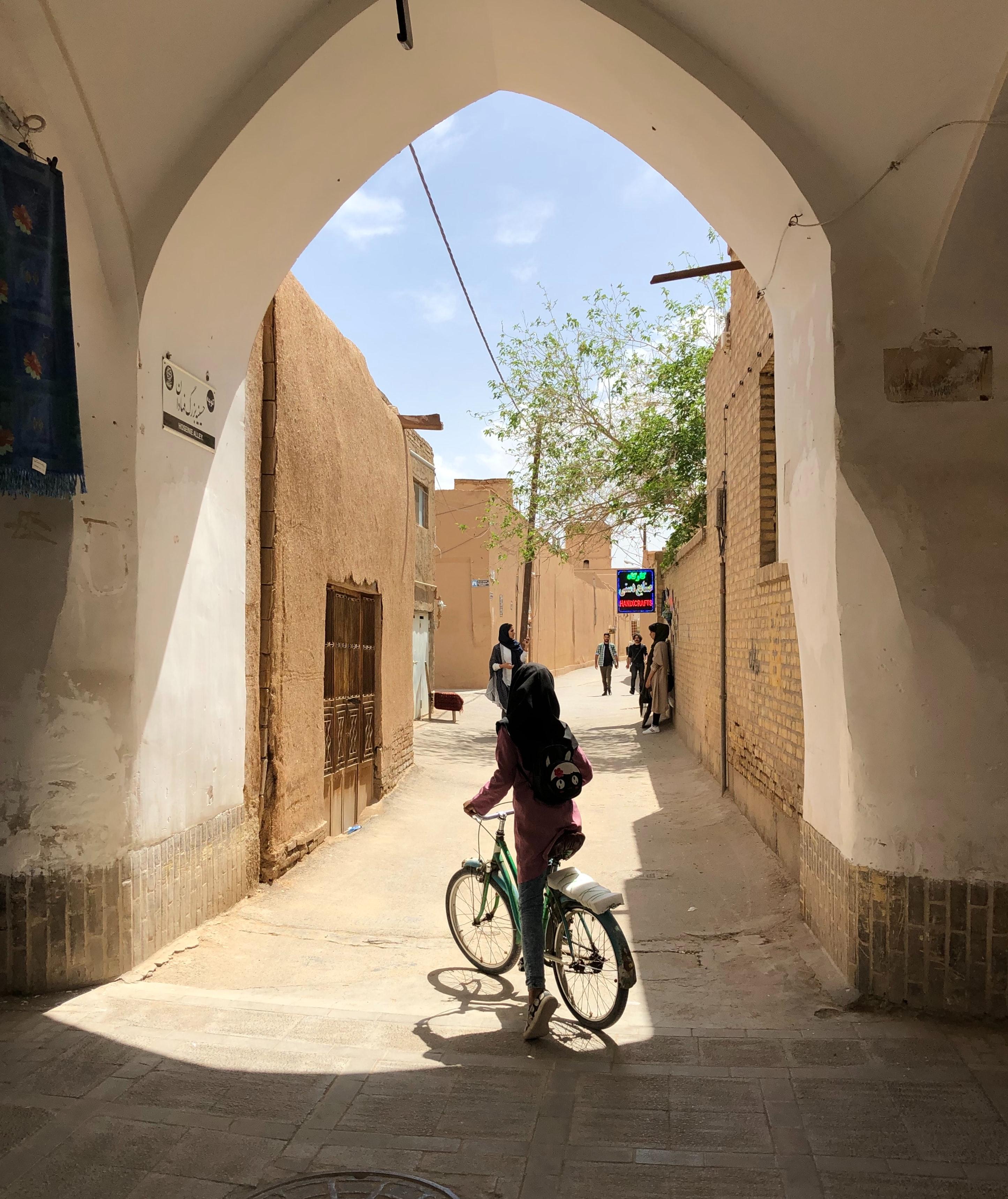 Cyclist in the shaded alley way of Old Town © Alessio Patron / Unsplash