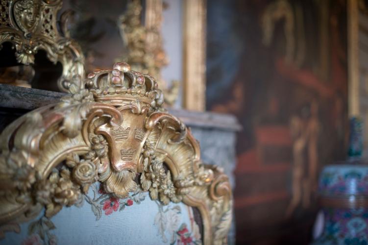 Chaque pièce regorge de nombreux détails à découvrir. Le Palais de Drottningholm est à la hauteur des plus hauts standards internationaux. Les trois couronnes suédoises décorent ce pare-étincelle rococo dans le salon Ehrenstrahl. – © Kate Gabor