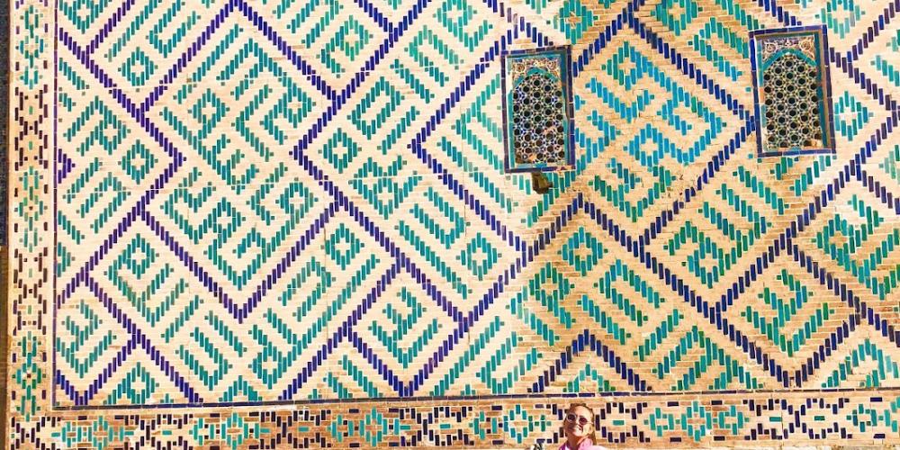 A woman poses in front of a beautifully decorated facade in Uzbekistan – Credit: Jennifer Lundt A woman poses in front of a beautifully decorated facade in Uzbekistan – Credit: Jennifer Lundt