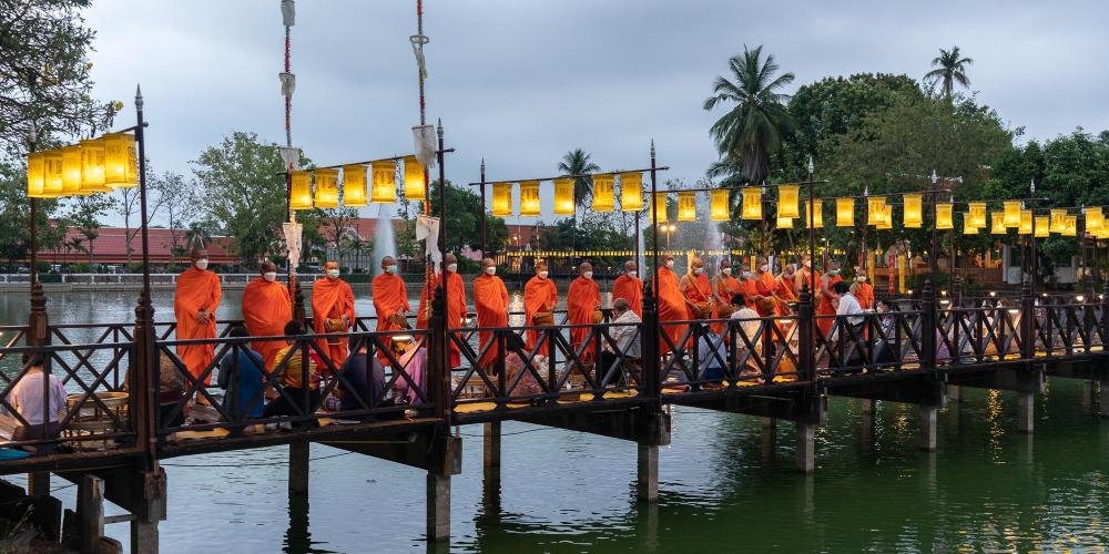 The monks line up on the bridge at Wat Traphang Thong to bless the assembled crowd. – © Michael Turtle