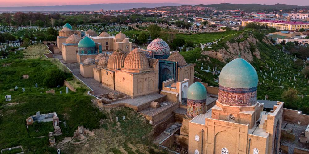 Beautiful sunset over old Uzbek buildings and lush green hills – © Farhodjon Arslonov / Shutterstock Beautiful sunset over old Uzbek buildings and lush green hills – © Farhodjon Arslonov / Shutterstock