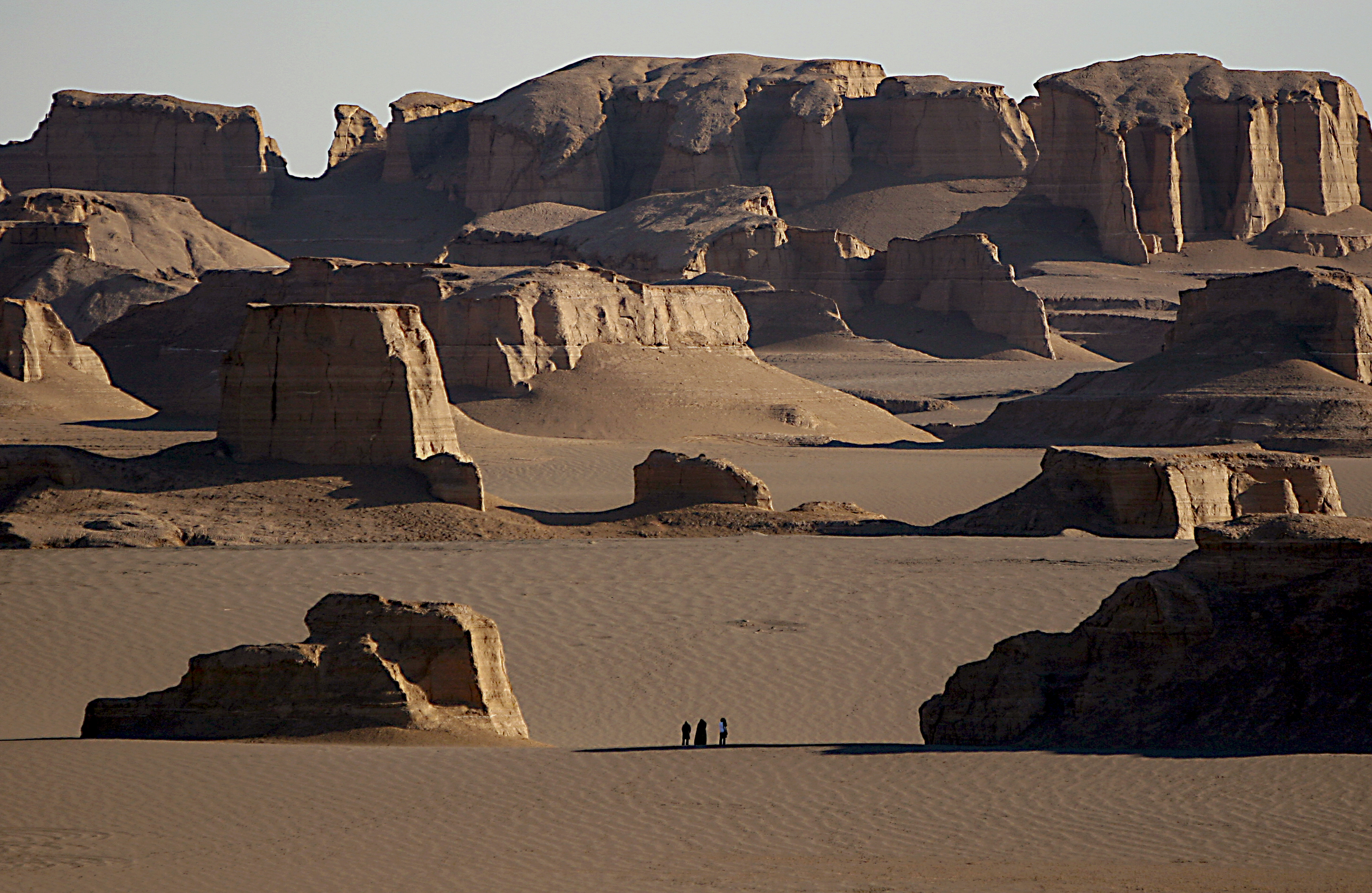 Tourists admiring yardangs in Lut Desert.