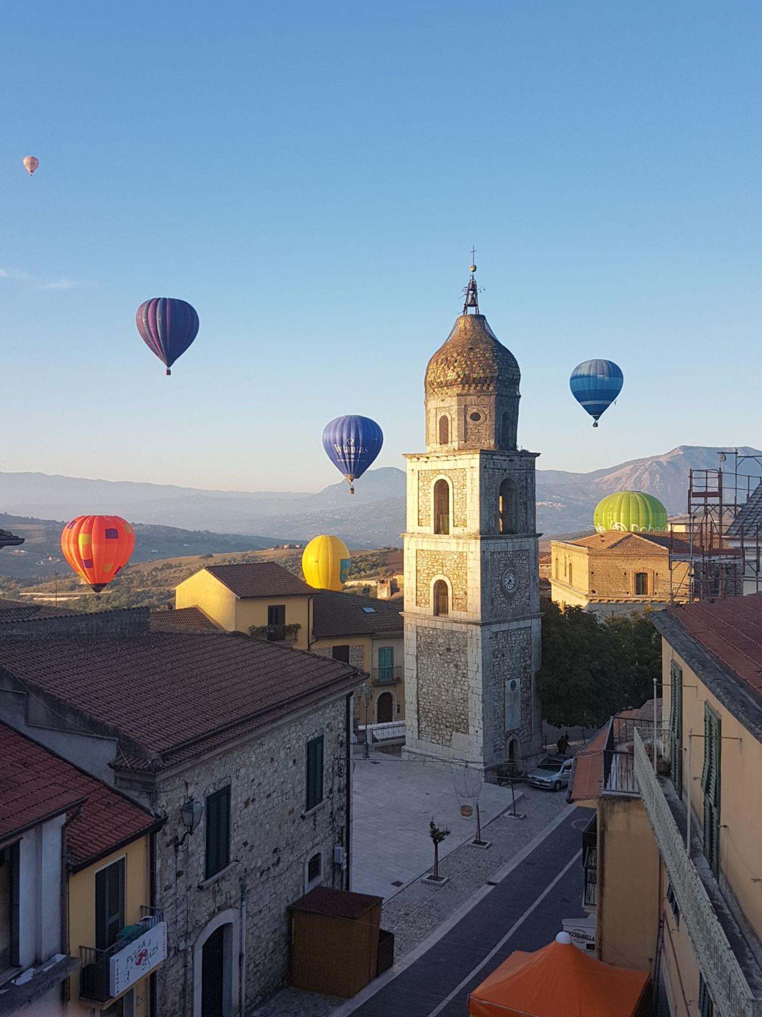 Balloons in flight over the churchyard of St. Nicholas and St. Rocco with the bell tower. – © Archivio Balooning Festival