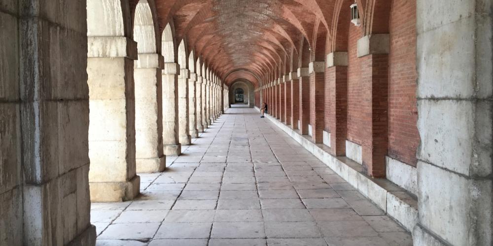 Covered arcade along the Plaza side of the Royal Palace of Aranjuez. – © Frank Biasi