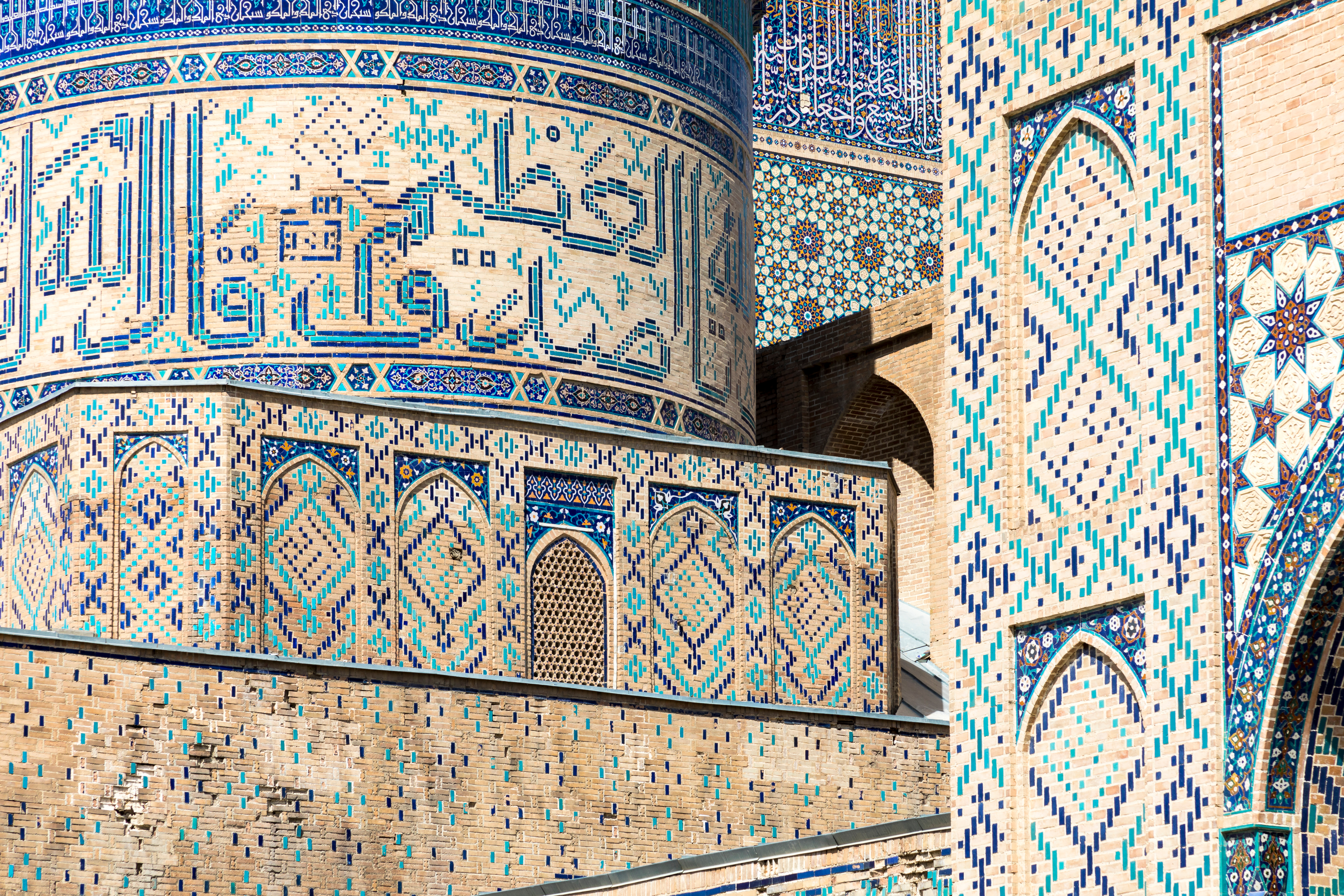 Intricate blue and purple tiling creating geometric shapes and Arabic words © Curioso.Photography / Shutterstock