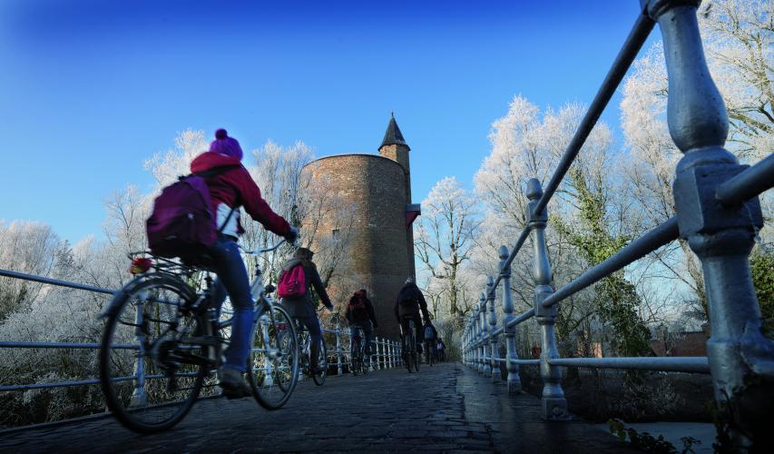 Besides romance, there are a lots of activities to enjoy, like biking near the "Poertoren." – © Jan Darthet / Visit Bruges