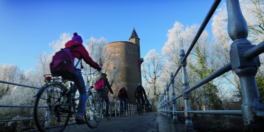 Besides romance, there are a lots of activities to enjoy, like biking near the "Poertoren." – © Jan Darthet / Visit Bruges