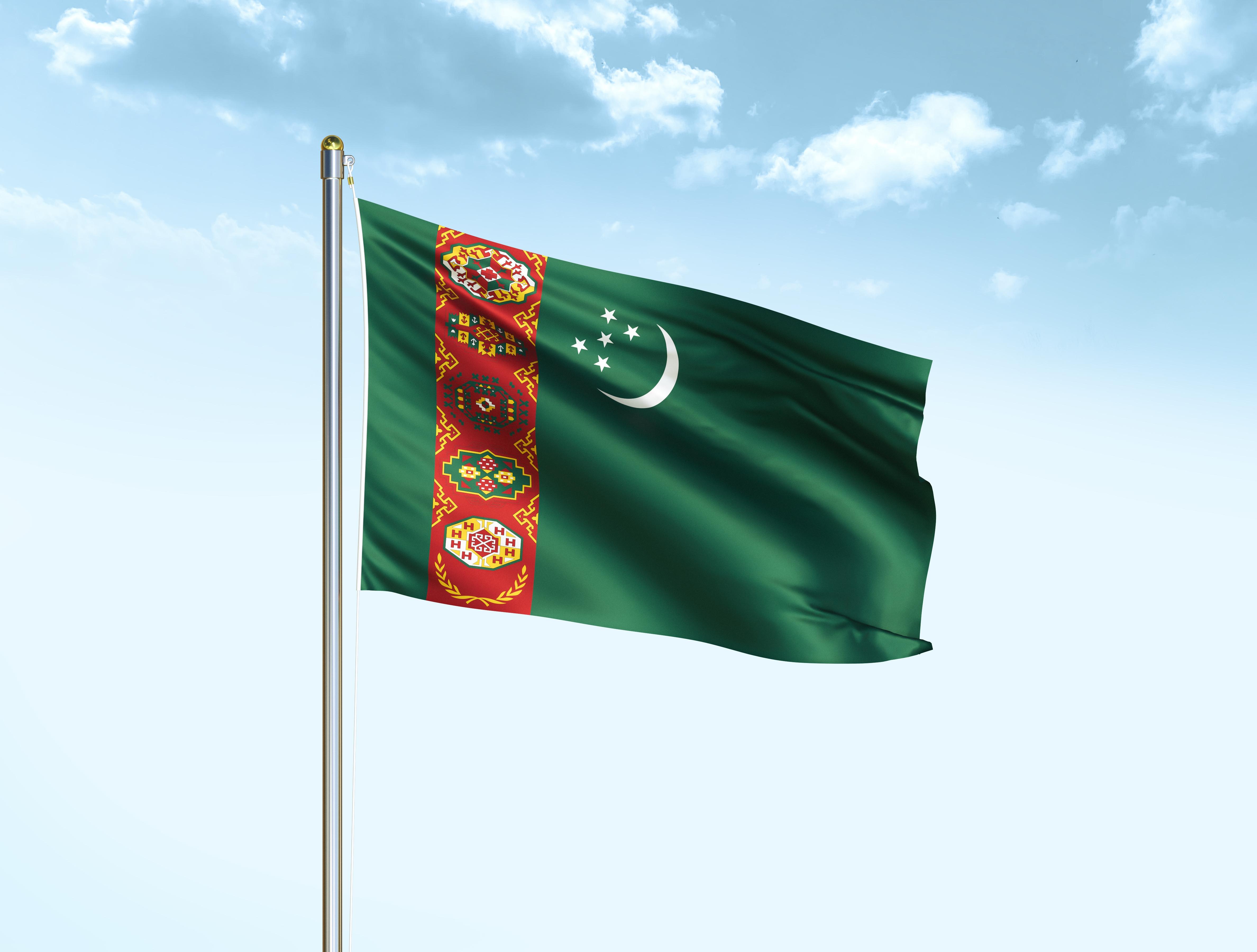The flag of Turkmenistan is proudly displayed atop the towering flagpole. © M_Videous / Shutterstock