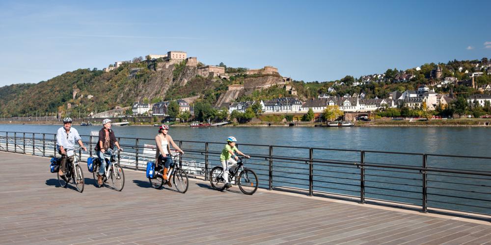 The cycle path on the left bank is continuous. On the other side is the gateway to the World Heritage Upper Middle Rhine, Koblenz. – © P. Gawandtka / ECF DEMARRAGE LTM, Rom. Rhein Tourismus GmbH