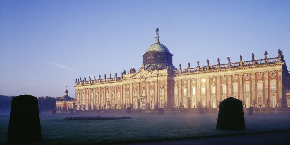 Le haut dôme de tambour de l'immense palais se dresse à l'extrémité ouest de la Hauptallee (la promenade principale) dans le parc de Sanssouci. – © H.Bach/SPSG