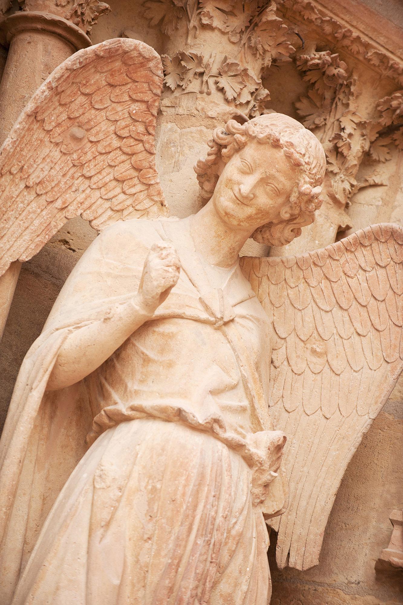 Famous smiling angel on the facade of the Reims Cathedral. – © Natalia Bratslavsky / Shutterstock.com