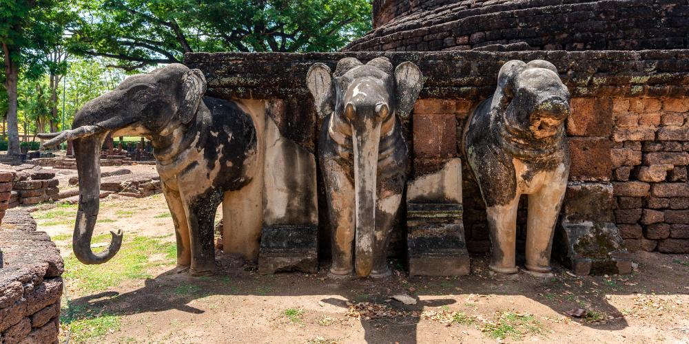 Elephant sculptures along the base of a round pagoda in the Wat Phra Kaeo temple. – © Michael Turtle
