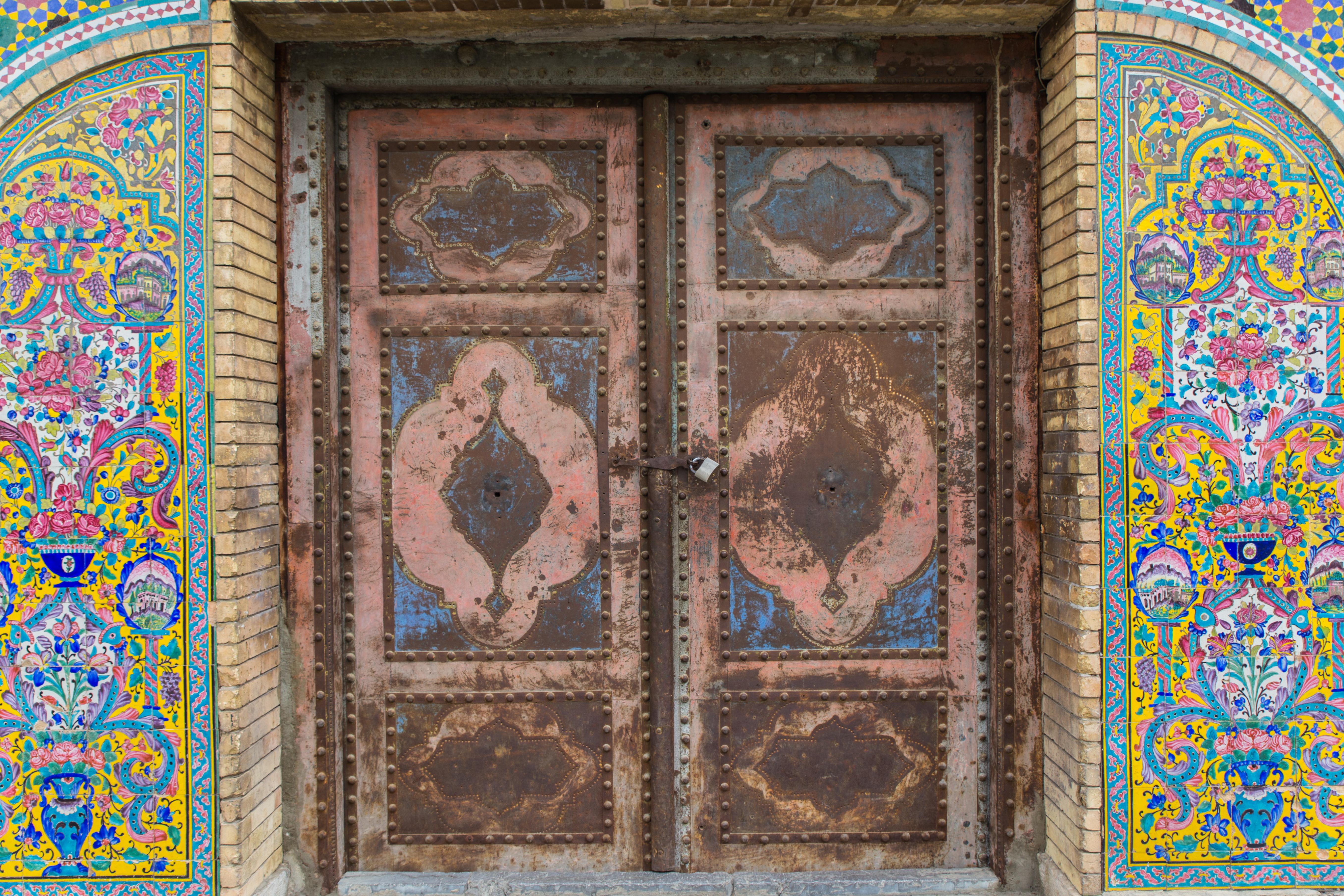 Intricate antique doors make an interesting contrast against the colorful tile