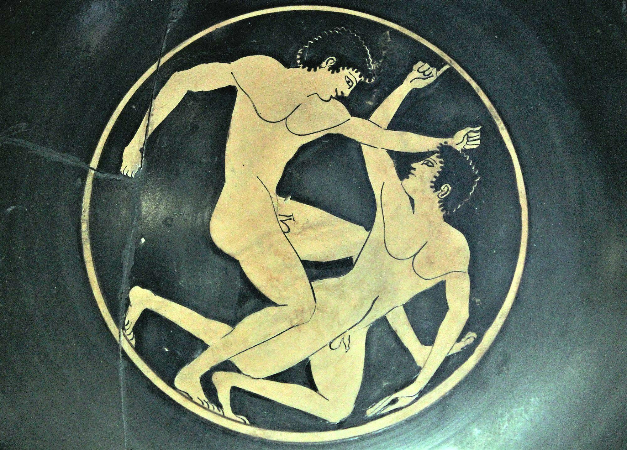 Scene from the interior of a red figure cylix (drinking cup) from the Athenian Agora—two young athletes competing in boxing. – © Hellenic Ministry of Culture and Sports / Ephorate of Antiquities of Ilia