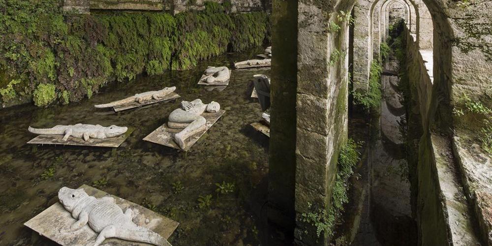 Since 1998, the calm waters of the Fonte delle Fate—or Fairies’ Spring—and its massive structure have watched over "I Dormienti" (The Sleepers), as they sleep. This series of bronze sculptures was created by Mimmo Paladino (Arte all’Arte 1998). – © Stefano Cannas / Fondazione Sistema Toscana