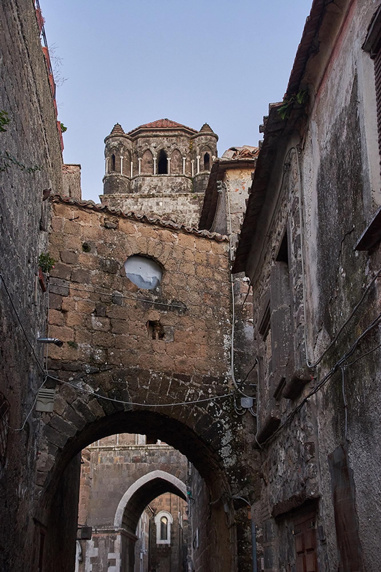 Characteristic narrow street of the ancient village of Casertavecchia, with the profile of the bell tower. – © Emma Taricco