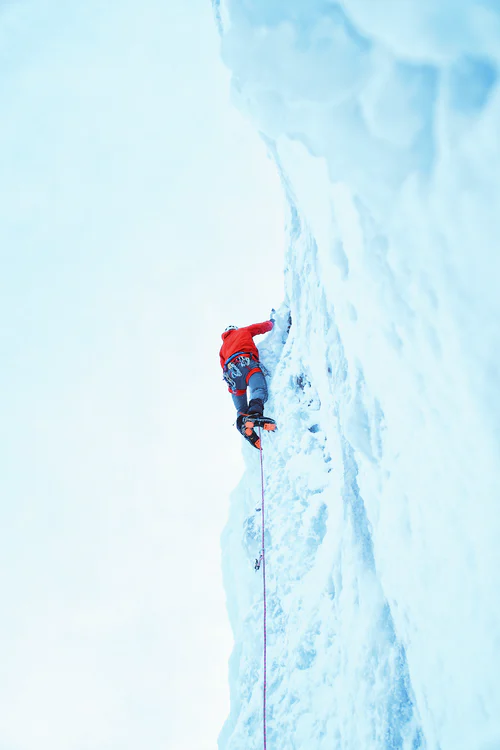 Ice climbing up a waterfall © Greg Rakozy / Unsplash