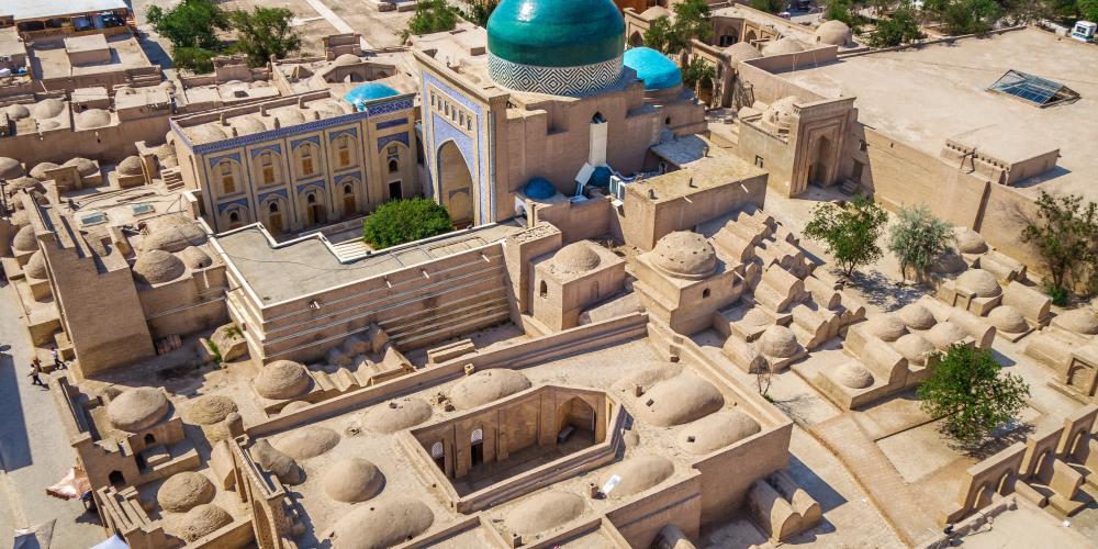 Historical buildings of Khiva (Uzbekistan) from above. Building with green dome is mausoleum of Pahlavan Mahmoud. Foreground: Mazar-i-Sharif madrasah and ancient mausoleums and tombstones of nobility – © Poliorketes / Shutterstock Historical buildings of Khiva (Uzbekistan) from above. Building with green dome is mausoleum of Pahlavan Mahmoud. Foreground: Mazar-i-Sharif madrasah and ancient mausoleums and tombstones of nobility – © Poliorketes / Shutterstock