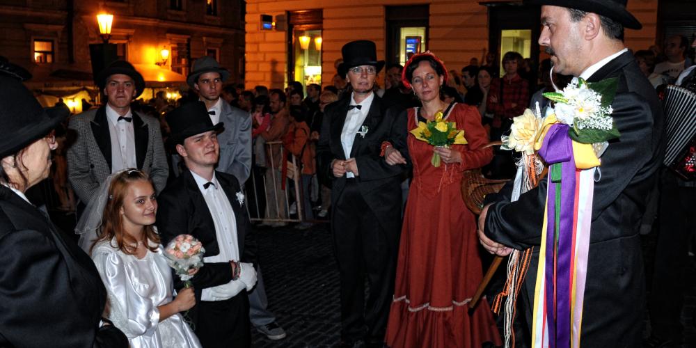 A merry company representing a wedding procession is formed by the accordion player, wedding chairman, bride, groom, bridesmaids, best men, wedding parents, and witnesses. – © Marian Garai A merry company representing a wedding procession is formed by the accordion player, wedding chairman, bride, groom, bridesmaids, best men, wedding parents, and witnesses. – © Marian Garai