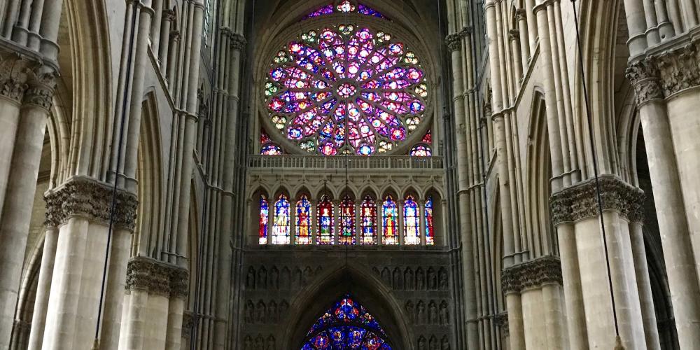 Stained glass rosette on the west facade of Reims Cathedral. – © Frank Biasi