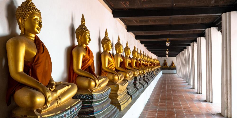 Rows of golden Buddha statues in the cloisters of Wat Phutthaisawan. – © Michael Turtle