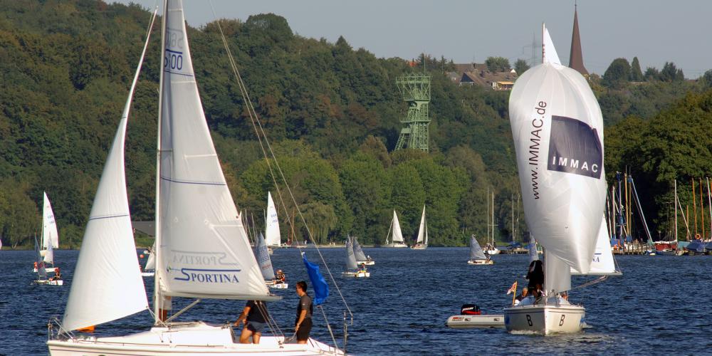 Des plaisanciers s’adonnent à leur passion sur le lac de Baldeney. Sur la rive nord du lac est toujours visible la tour de l'ancienne mine de charbon Carl Funke. – © Editing Department / City of Essen Des plaisanciers s’adonnent à leur passion sur le lac de Baldeney. Sur la rive nord du lac est toujours visible la tour de l'ancienne mine de charbon Carl Funke. – © Editing Department / City of Essen