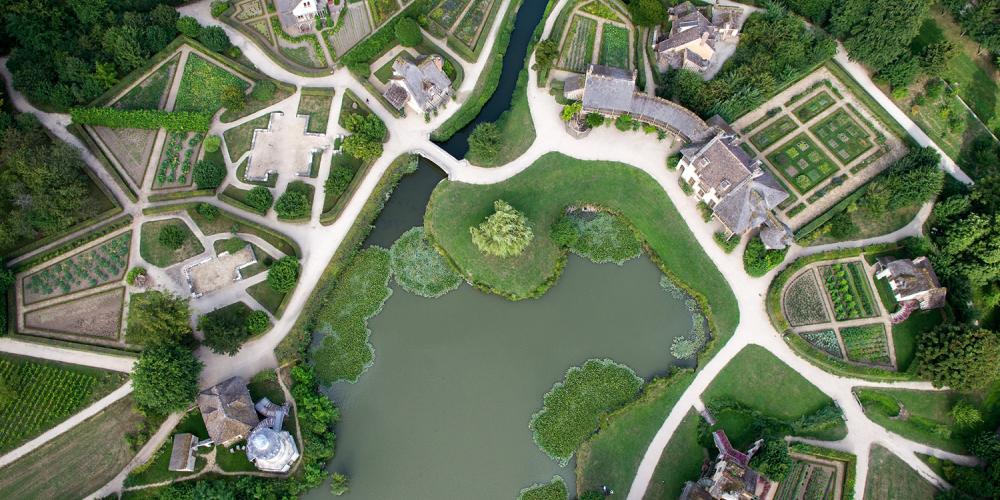 Following the European taste for the “fermes ornées,” Marie-Antoinette tasked Richard Mique with extending the gardens to the north and building a whole model village around an artificial lake. Combining various influences from rural architecture, the queen enjoyed an etiquette-free life with her close friends in her cozy cottage. – © Toucan Wings Following the European taste for the “fermes ornées,” Marie-Antoinette tasked Richard Mique with extending the gardens to the north and building a whole model village around an artificial lake. Combining various influences from rural architecture, the queen enjoyed an etiquette-free life with her close friends in her cozy cottage. – © Toucan Wings