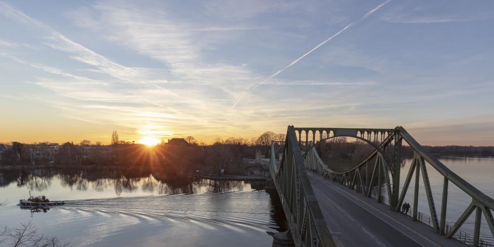 The Glienicke Bridge once marked the border between West Berlin and Potsdam. Due to its location, captures spies were exchanged here between East and West giving the bridge it's nickname "Bridge of Spies". 
Today the Glienicke Bridge is the gateway to the Potsdam lakescape. – © PMSG, André Stiebitz