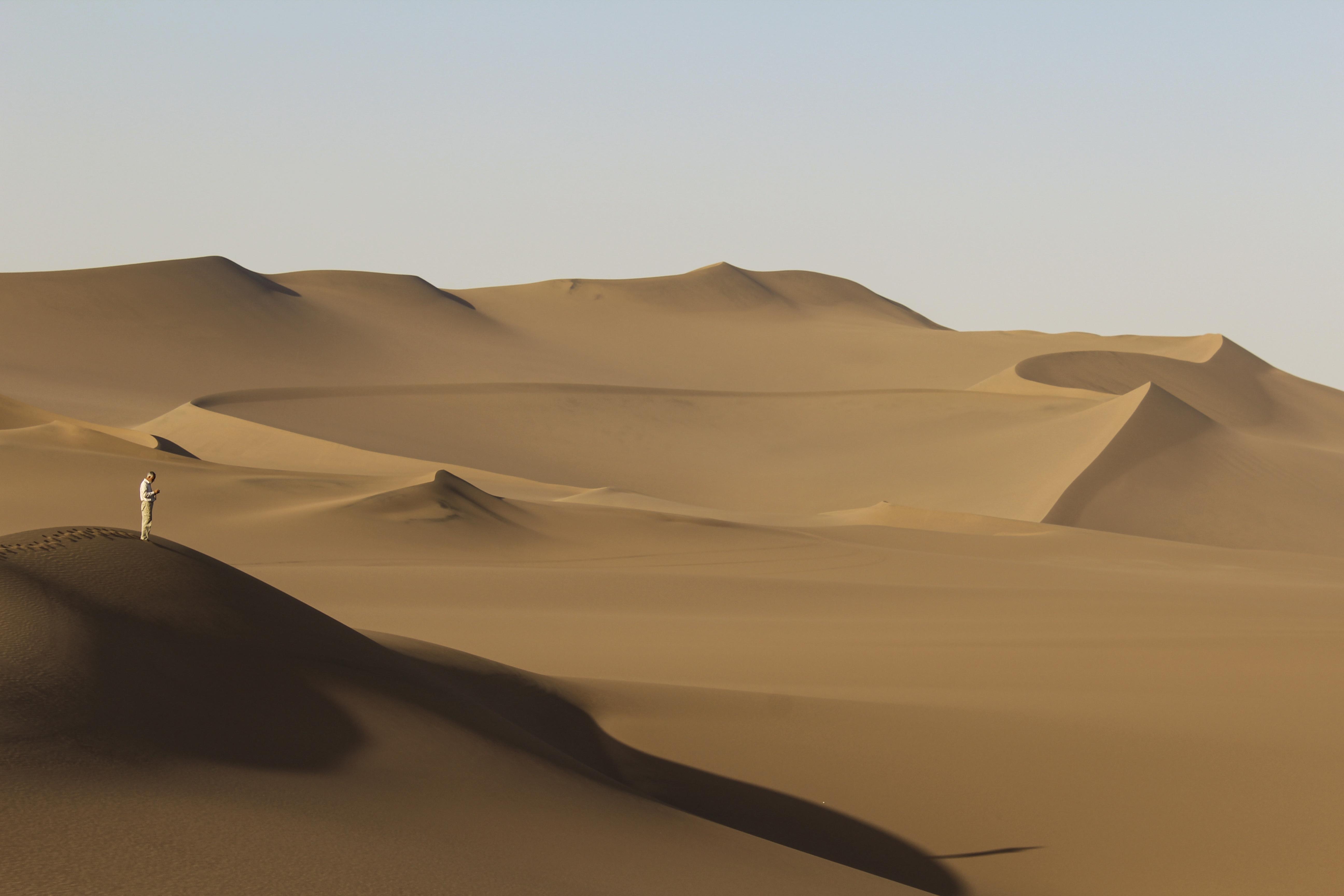 A visitor looks out across the vast expanse of the Lut Desert