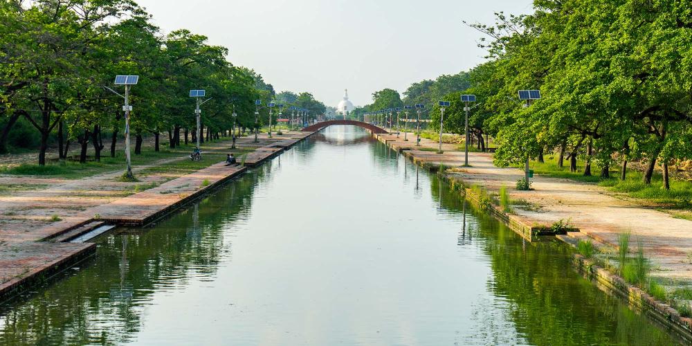 A long canal runs down the centre of Lumbini, representing the journey that Buddhist pilgrims take towards enlightenment. – © Michael Turtle