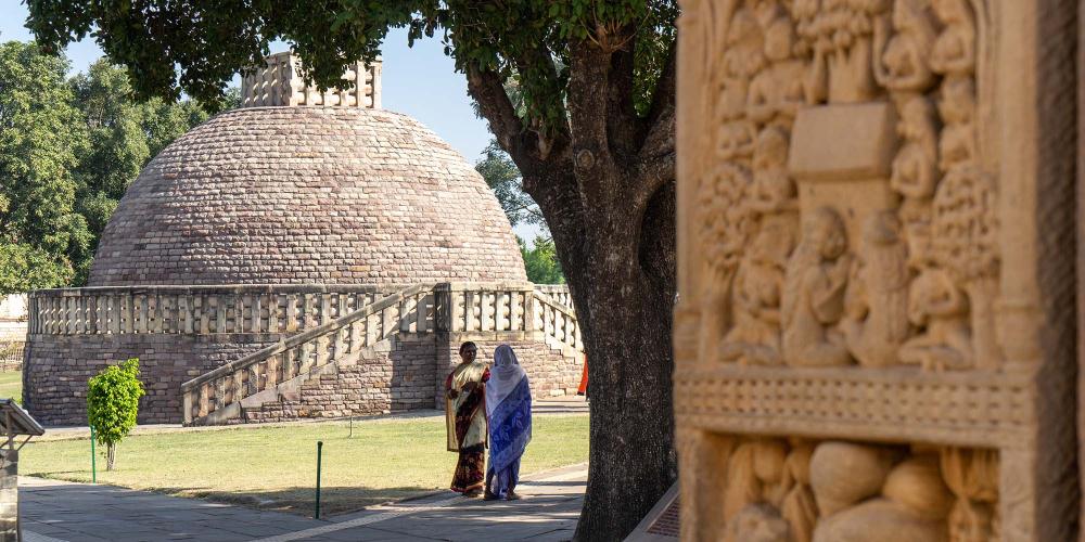 Stupa number 3 on the main terrace at Sanchi, as seen through the carved northern gateway of the Great Stupa. – © Michael Turtle