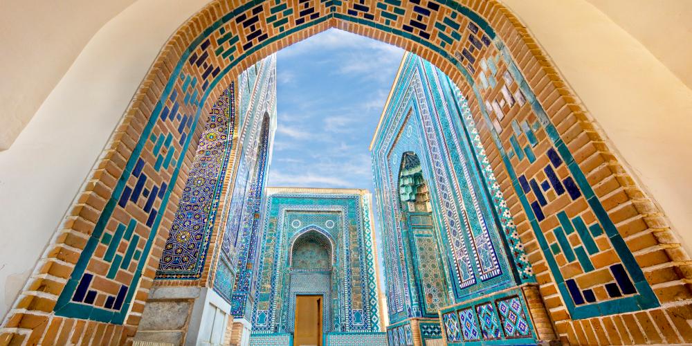Historical cemetery of Shahi Zinda with its finely decorated mausoleums through an arch in Samarkand, Uzbekistan – © MehmetO / Shutterstock Historical cemetery of Shahi Zinda with its finely decorated mausoleums through an arch in Samarkand, Uzbekistan – © MehmetO / Shutterstock