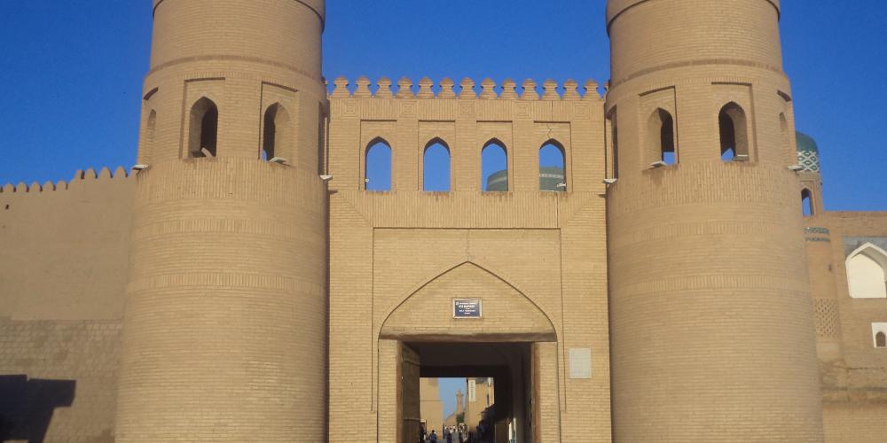 Twin-turreted West Gate with Madrassah of Muhammad Amin-khan in background – Khiva, Uzbekistan – Photo by Helen Turner