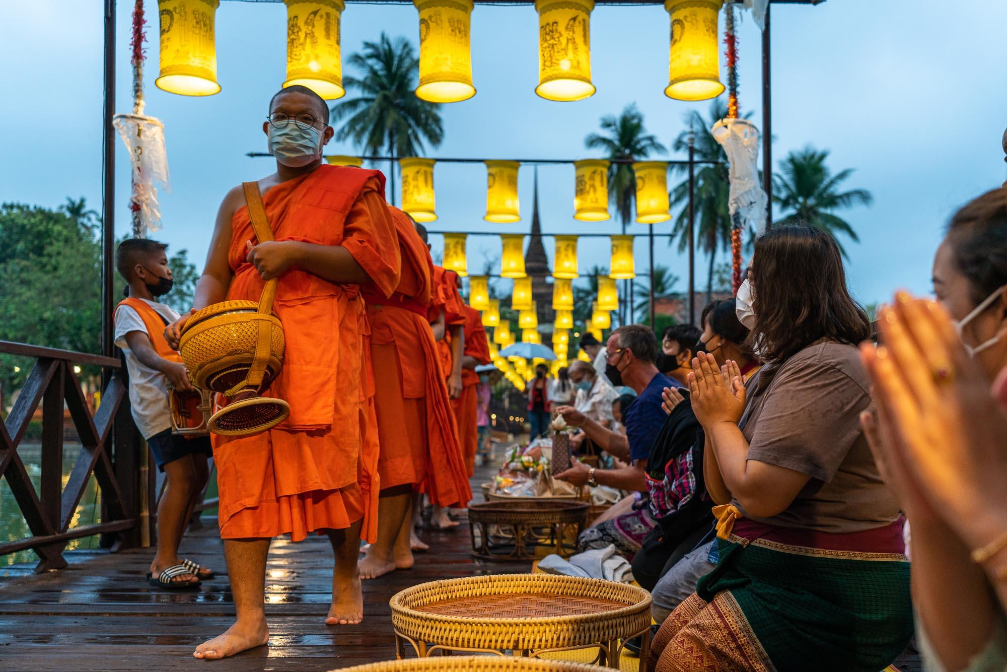 Monks receive offerings at the daily alms-giving ceremony at Wat Traphang Thong in Sukhothai. – © Michael Turtle