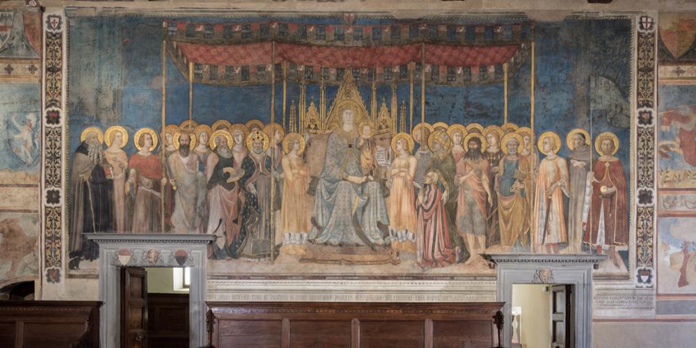 Before admiring the frescos in Camera del Podestà, you should go to Sala Dante to visit the Maestà painted by Lippo Memmi in 1317. – © Musei Civici San Gimignano