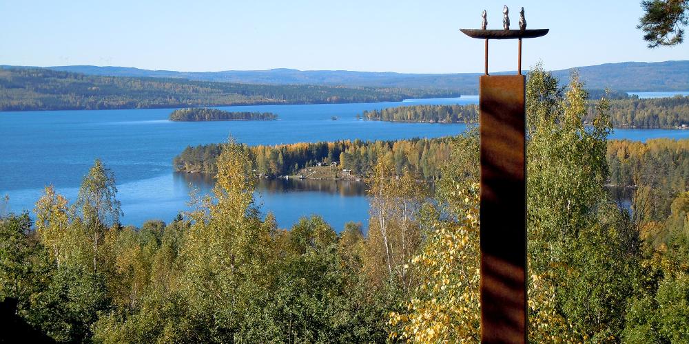 A shot from the Lekomberg mine outside Ludvika, shows the forest and river, and a sculpture made from iron and steel. – © Ekomuseum Bergslagen