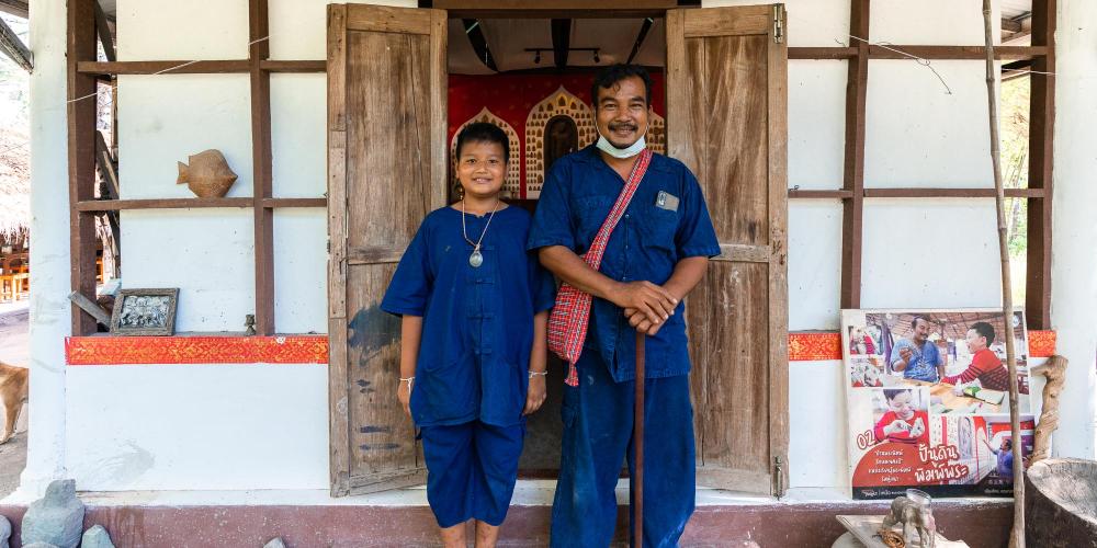 Specialist guide Narongchai Toain (right) welcomes visitors to his home to teach them how to make amulets. – © Michael Turtle