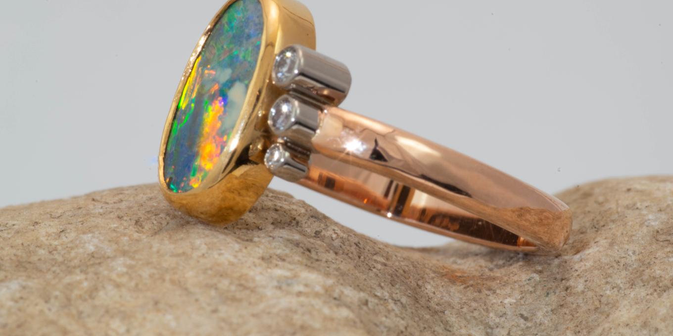 2 carat Australian Boulder Opal accented with three collection quality diamonds in 18-22 karat rose gold, yellow gold and white gold hand fabricated ring. $3,750.00 – Beautiful Opal who's fire resembles the reflection of the most colorful sunset reflected of glacier waters.
