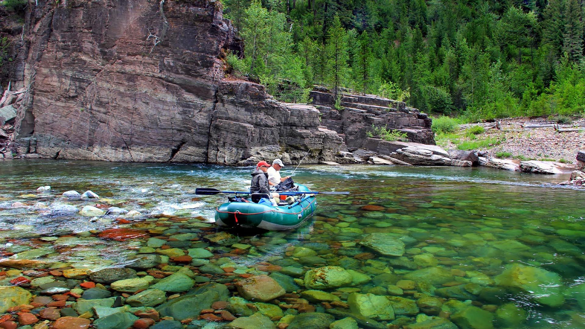 A man fly fishing in the Montana mountains Flathead River, MT JC Spock