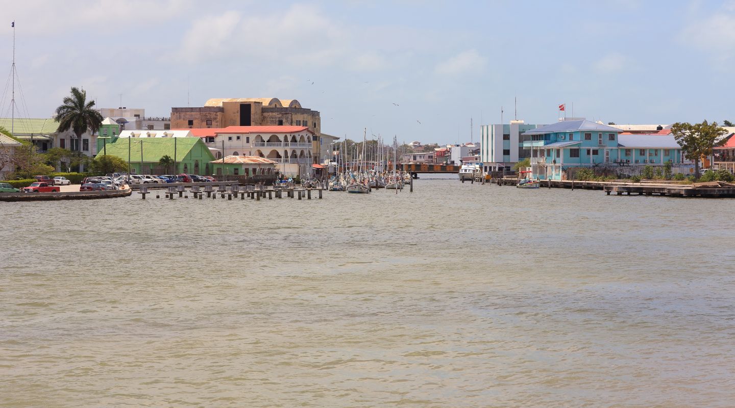 Two rows of colorful houses seen from a river running between them. 