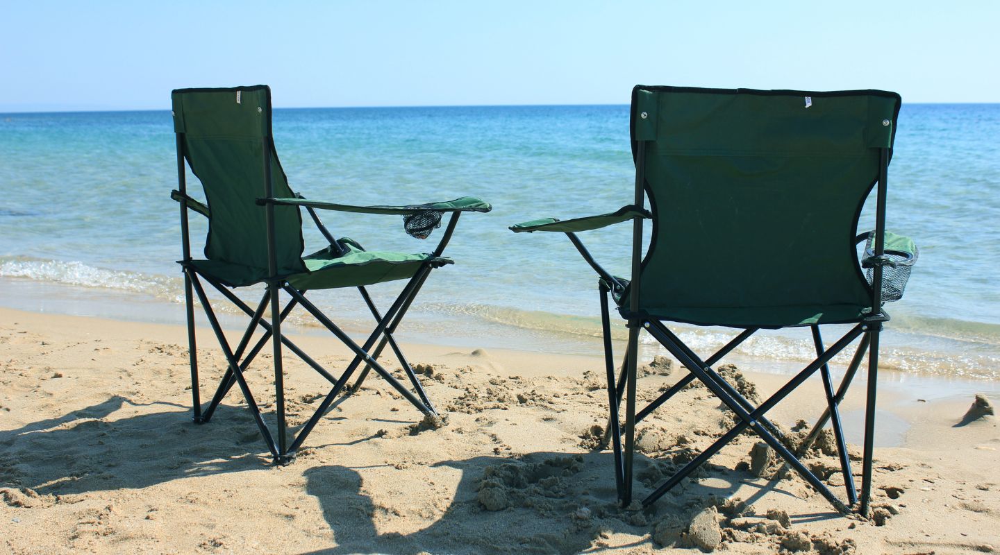 A pair of folding chairs on the beach